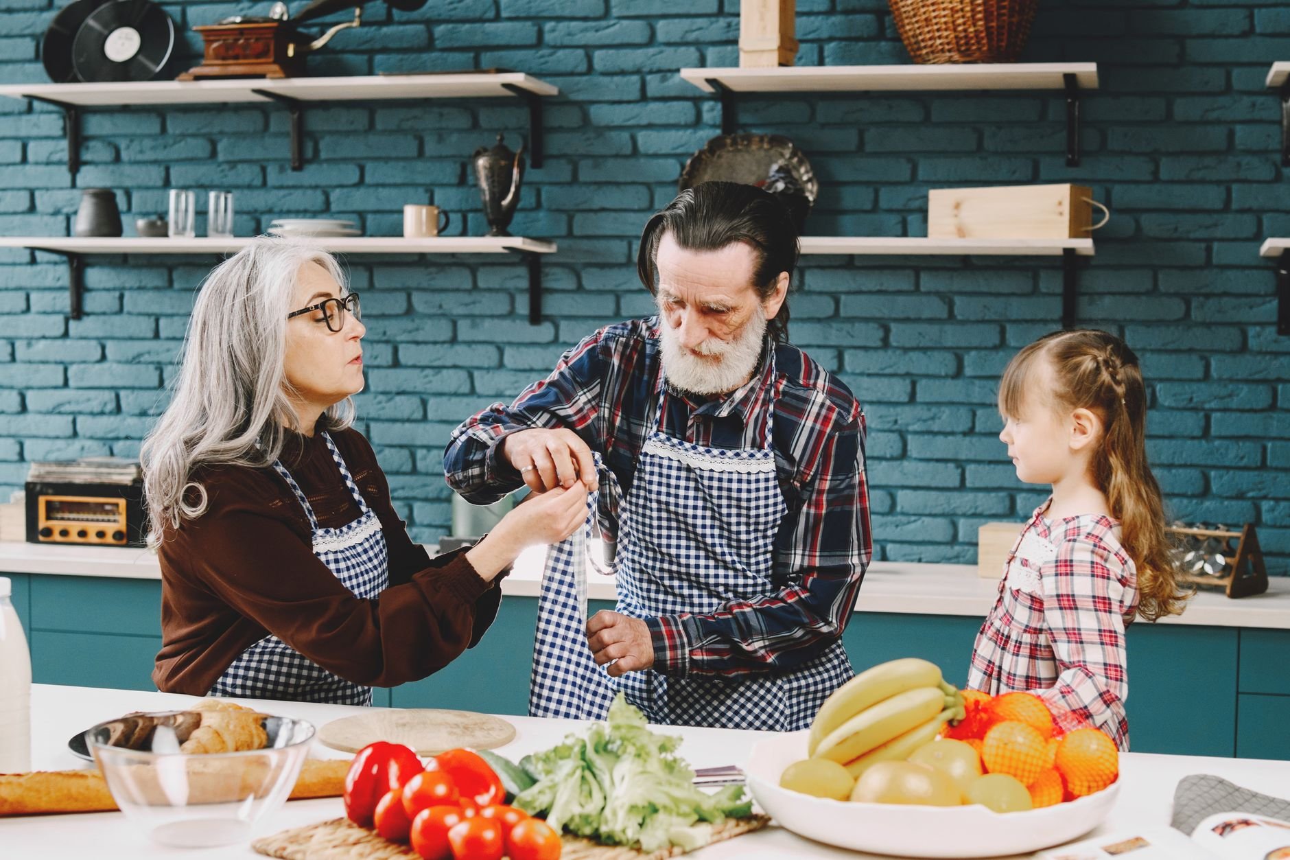 Senior couple and grandchild bonding over cooking in a cozy kitchen setting, enjoying quality time together.